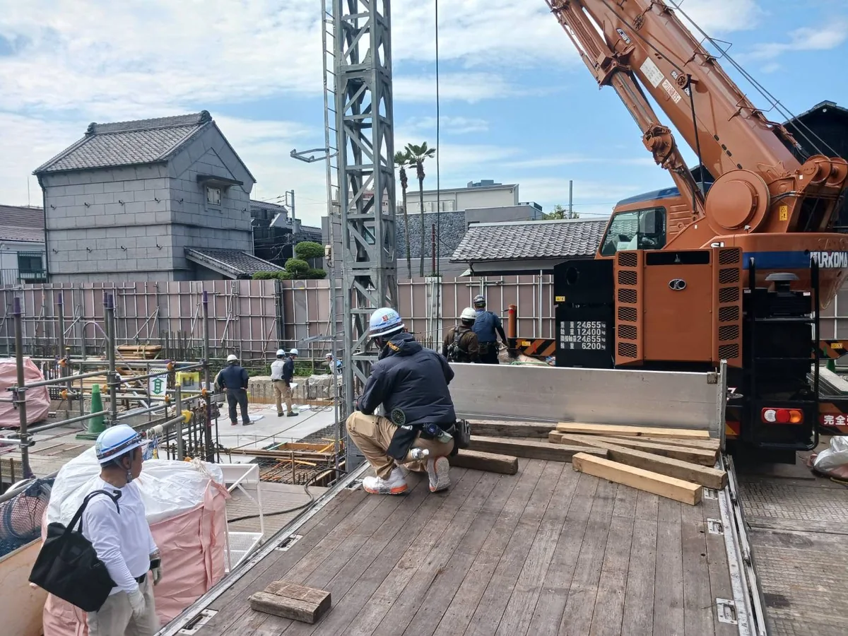 クレーンがある搬入先で作業するスタッフ